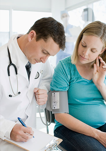 Doctor measures blood pressure from a pregnant women (photo)