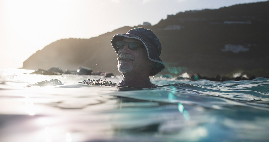 Mann genießt die Sonne im Wasser (Foto)