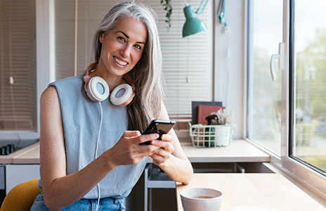 Woman is doing something on the phone and smiling (Photo)