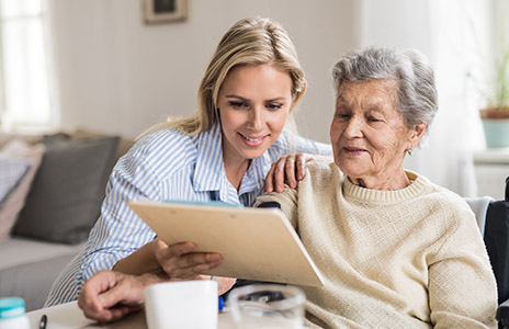 A young woman is helping an elder woman out to read something (Photo)