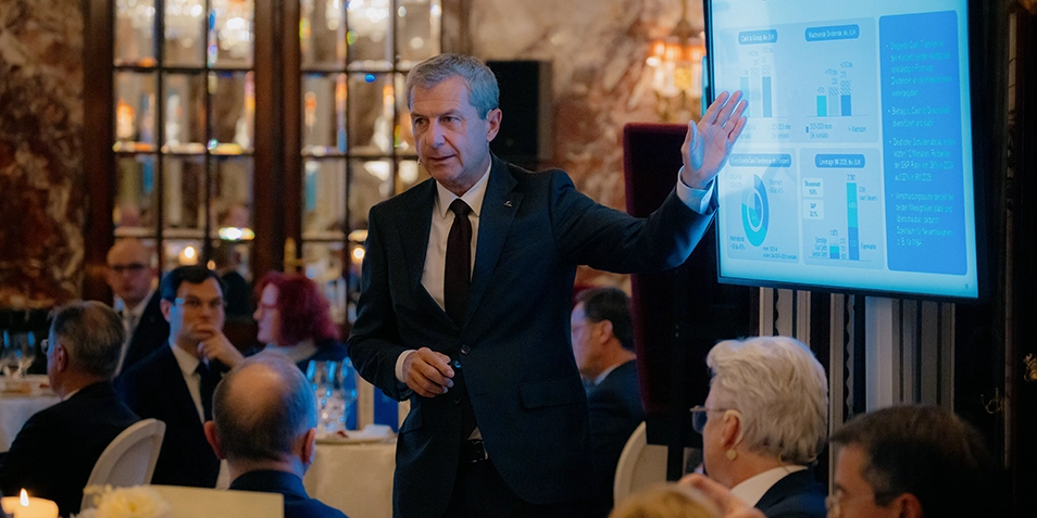 Kurt Svoboda presenting charts at a dinner event.
