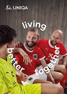 Three football players smiling and talking.
